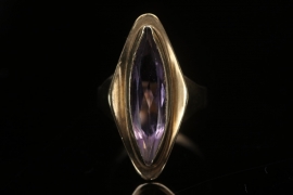 Golden ring with amethyst in an elongated-oval-cut